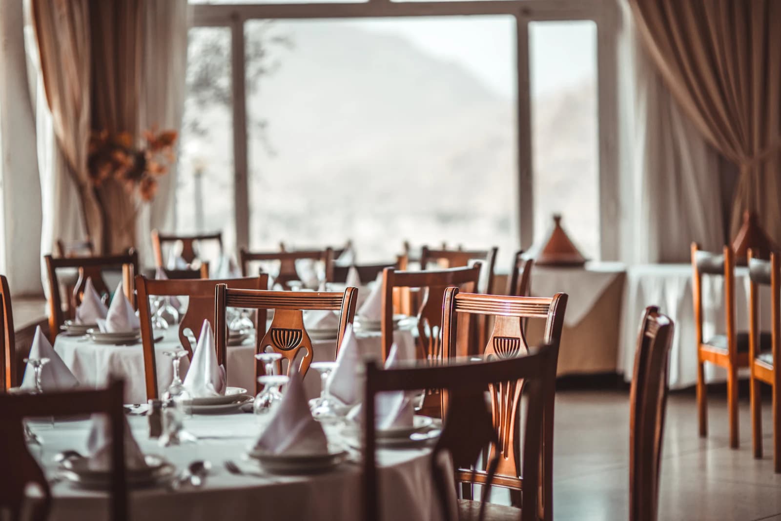 Dining room laid for service with pressed napkins, glassware and set tables