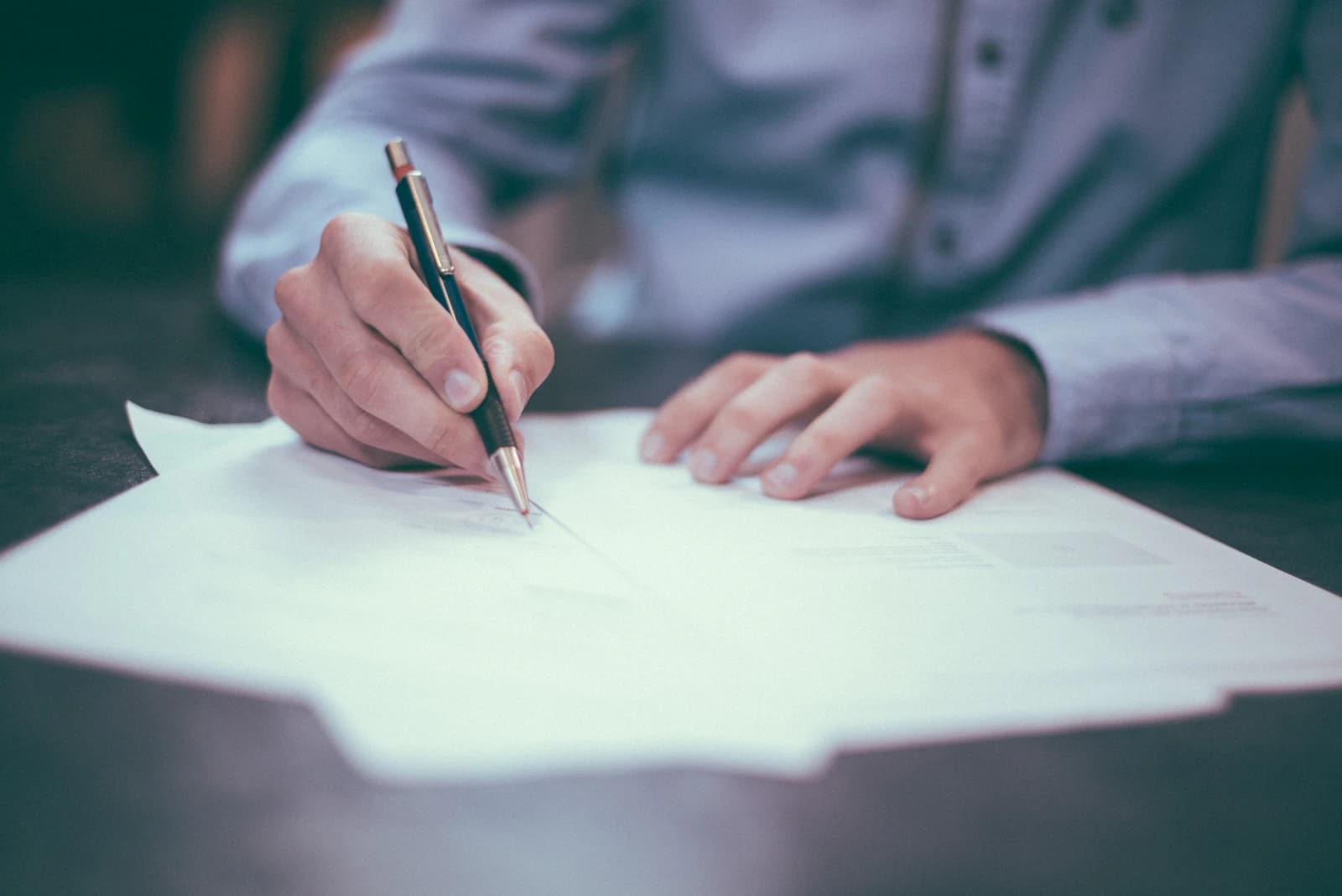 Hands writing notes on an audit checklist during a restaurant operations review