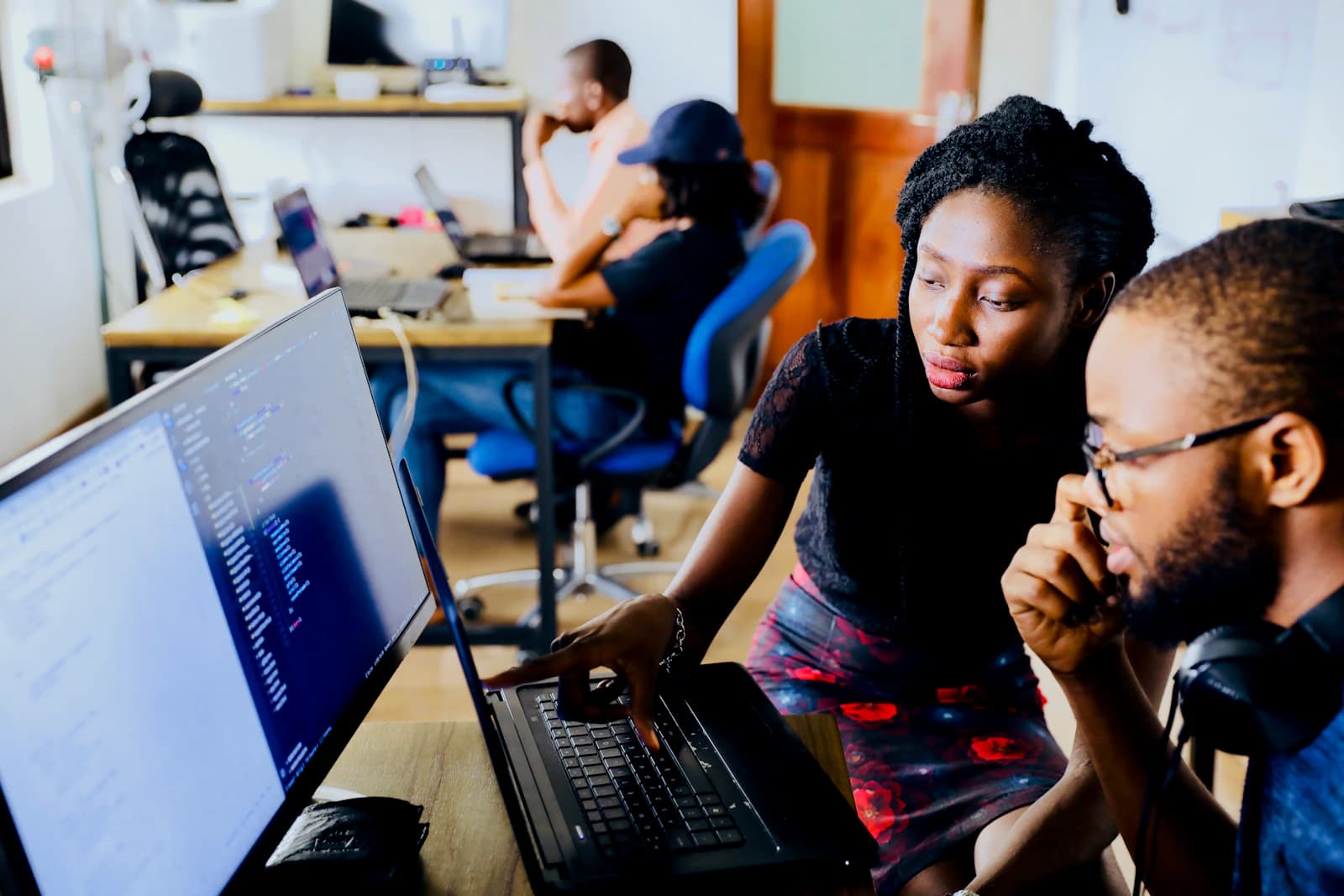 Two colleagues reviewing service notes together at a laptop