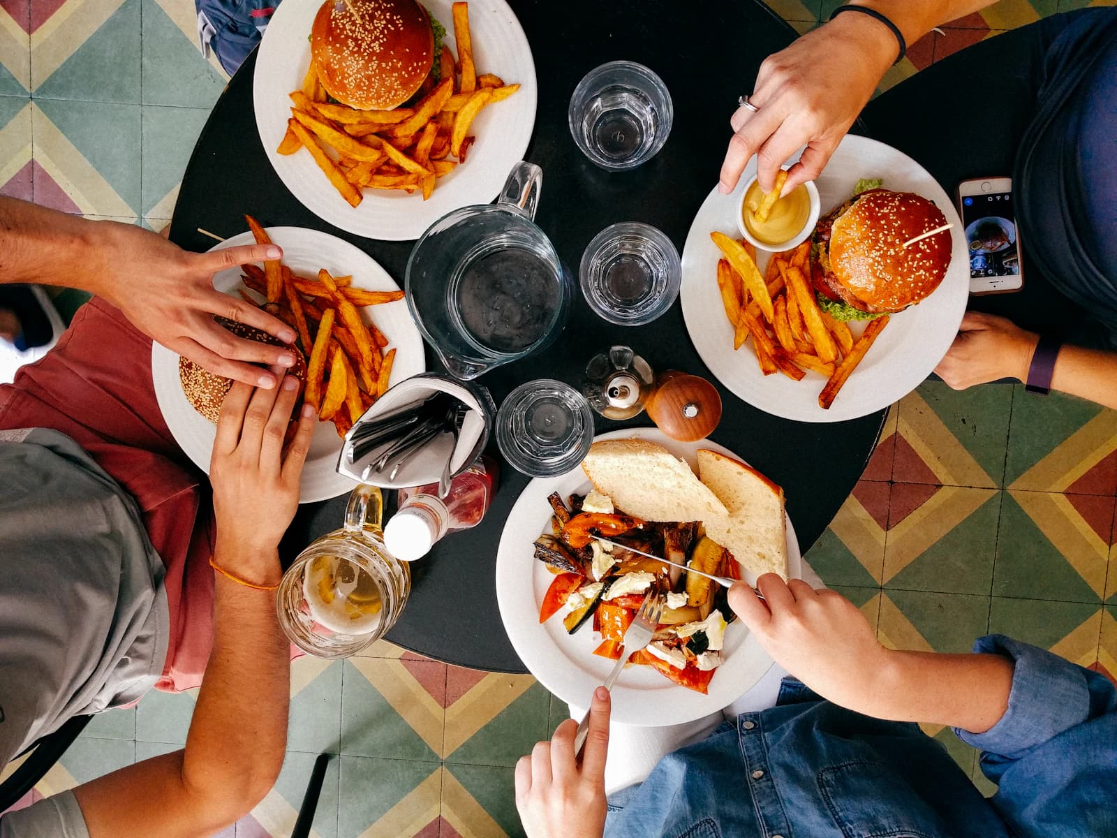Overhead view of guests sharing plates across a busy restaurant table